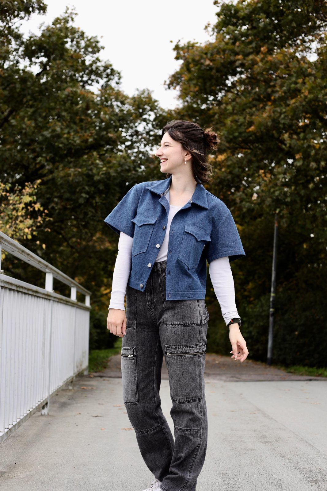 Jeansjacke, getragen beim Gehen über eine Brücke