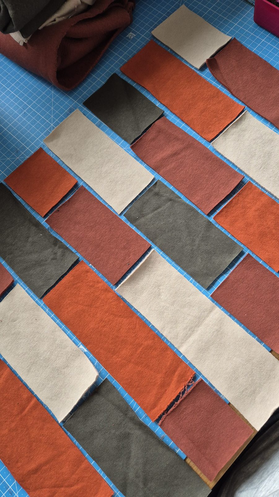 Patchwork-Quadrate in Rostrot, Creme und Oliv ausgelegt