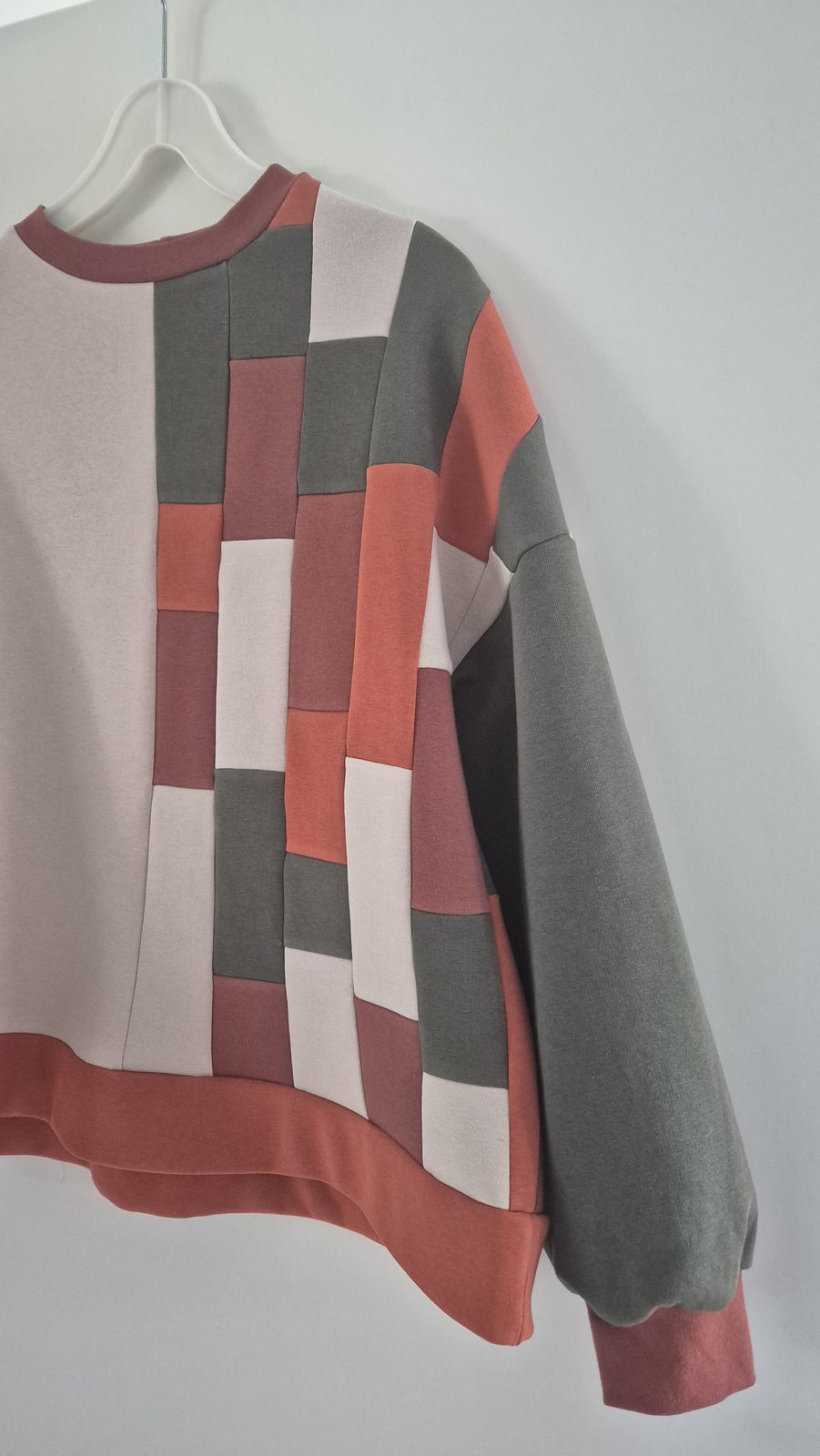 Fertiger Patchwork-Pullover auf einem Bügel