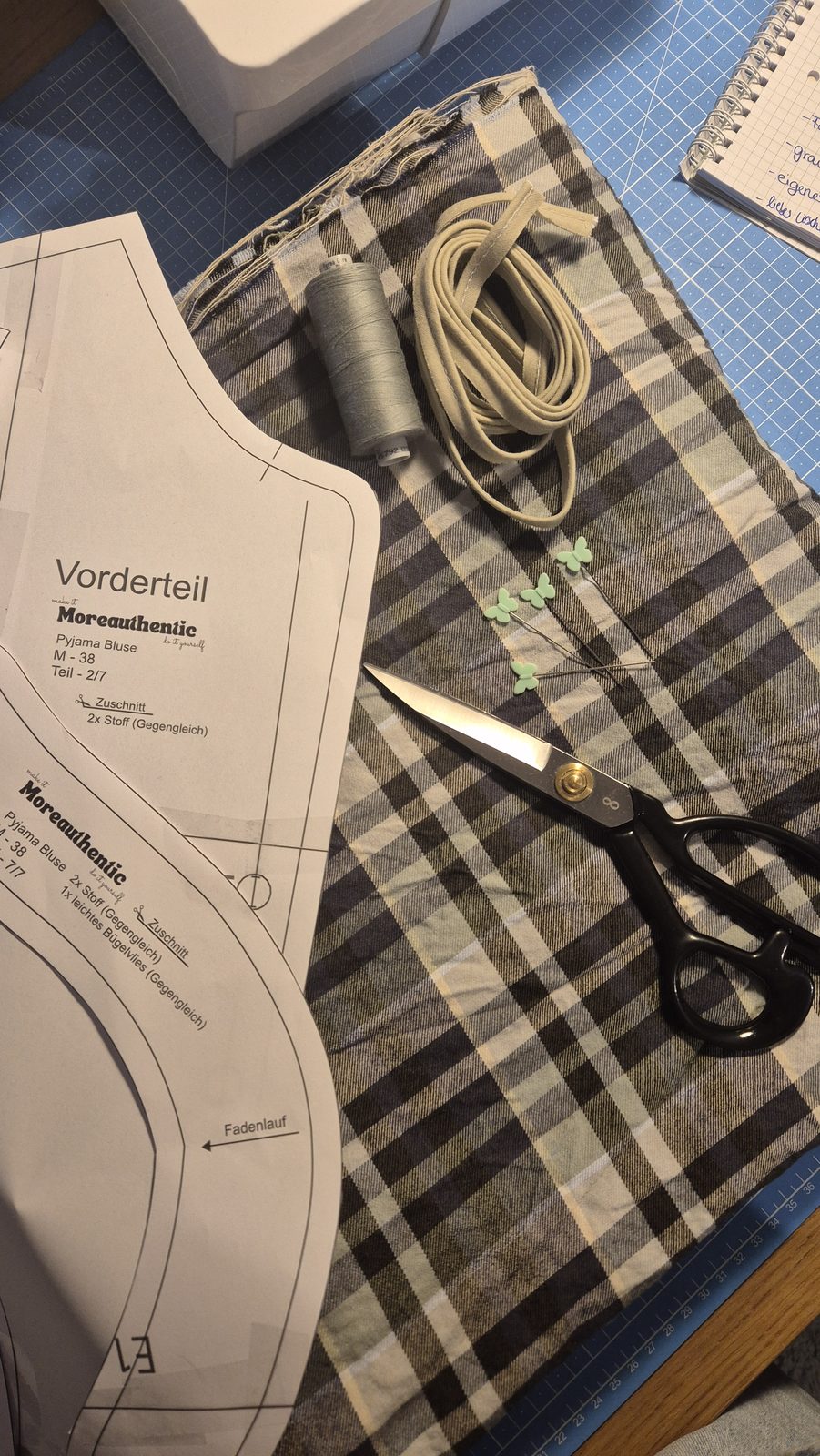 Schnittmuster und Schere auf kariertem Stoff