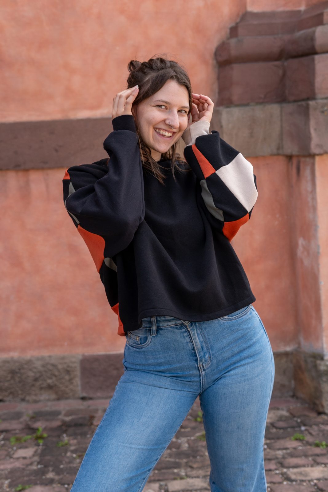 Der Boxy Sweater in Schwarz mit Ärmelflächen in Rost und Creme